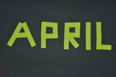 April month concept from a sticky notes paper gray background 