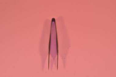 First aid kit tweezers on a pink background medical