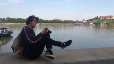 Nehir kıyısında fotoğraf çeken beyaz bir fotoğrafçı.