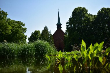 Gölün arkasındaki parkta bir kilise.