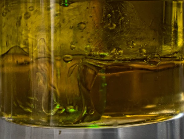 Abstracte Formaties Van Groen Laserschieten Een Glas Vol Olieachtige Vloeistof — Stockfoto