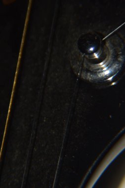 Akustik gitar tellerini kapatın. Akustik gitarın enstrüman tellerinin uç makro çekimi.