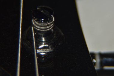 Bas gitar tellerini kapat. Enstrümanın aşırı makro çekimi kalın, bas gitarın metal telleri.