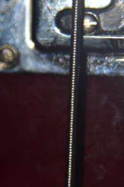 Bas gitar tellerini kapat. Enstrümanın aşırı makro çekimi kalın, bas gitarın metal telleri.