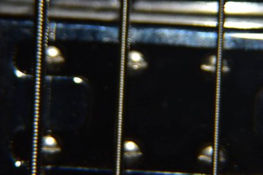 Bas gitar tellerini kapat. Enstrümanın aşırı makro çekimi kalın, bas gitarın metal telleri.
