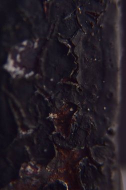 Çizgili siyah boyalı paslı bir metale yaklaş.