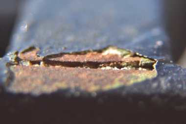 Çizgili siyah boyalı paslı bir metale yaklaş.