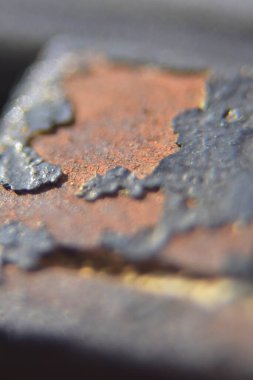 Çizgili siyah boyalı paslı bir metale yaklaş.