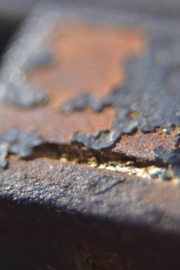 Çizgili siyah boyalı paslı bir metale yaklaş.