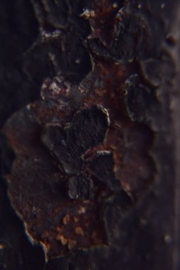 Çizgili siyah boyalı paslı bir metale yaklaş.