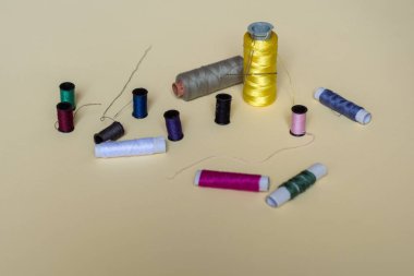 Dikiş ipliği ve iğne atölyesi çekimi. Sarı arka planda moda kavramı. 