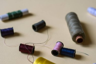 Dikiş ipliği ve iğne atölyesi çekimi. Sarı arka planda moda kavramı. 