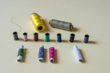 Dikiş ipliği ve iğne atölyesi çekimi. Sarı arka planda moda kavramı. 