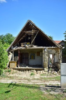 Eski, terk edilmiş, ön duvarı olmayan ev.