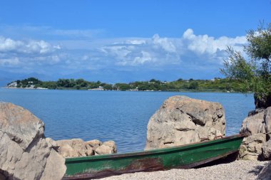 Göl kıyısındaki eski tekne. Karadağ 'ın Skadar Gölü' nde güneşli bir gün yolculuğu fotoğrafçılığı.