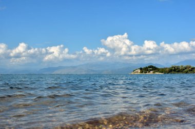 Göl kıyısında su dalgaları. Skadar Gölü güneşli gün doğa yolculuğu fotoğrafçılığı. 