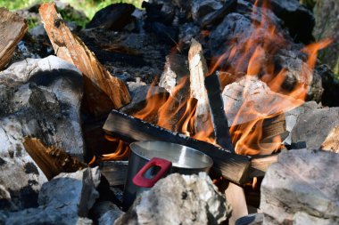 Doğada kamp ateşinde çaydanlık. Şebekenin içinde yaşamak. Kamp yapmak ve ormanda yemek pişirmek..