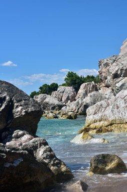 Güneşli bir günde sahilde kayalar. Adriyatik Denizi 'nin güzel arka plan manzarası. Yaz günlerinde doğa. 