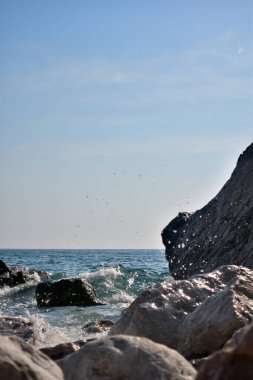 Kayalarda deniz sıçraması. Okyanus dalgası kayalık sahile çarpıyor. Doğanın manzara fotoğrafı..