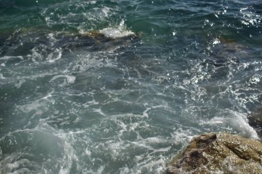 Kayalarda deniz sıçraması. Okyanus dalgası kayalık sahile çarpıyor. Doğanın manzara fotoğrafı..