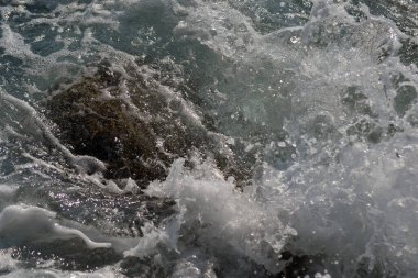 Kayalarda deniz sıçraması. Okyanus dalgası kayalık sahile çarpıyor. Doğanın manzara fotoğrafı..