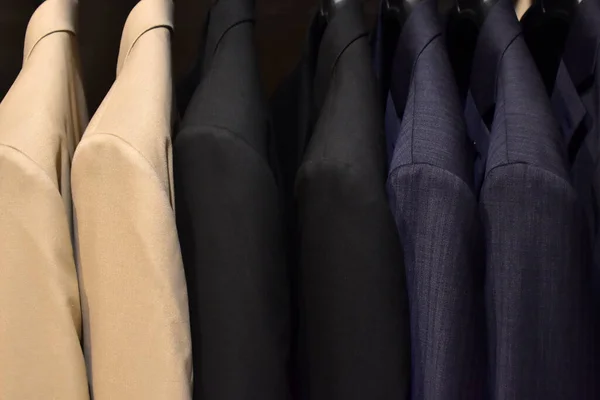 Suits on a clothing hanger. Merchandizing of clothes in a boutique. Clothing store fashion.