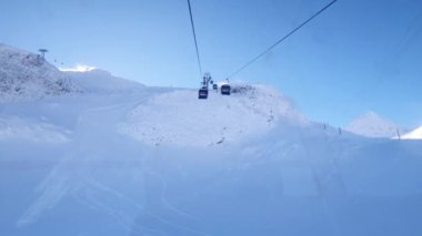 Avusturya Alpleri 'ndeki kış kayak merkezinde teleferik gezisi. Hintersmoxer buzulu. Güneşin, karın ve kayakçıların kış manzarası.