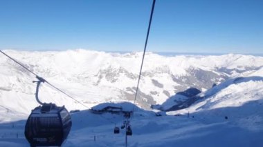 Avusturya Alpleri 'ndeki kış kayak merkezinde teleferik gezisi. Hintersmoxer buzulu. Güneşin, karın ve kayakçıların kış manzarası.