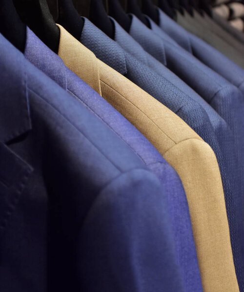 Suits on a clothing hanger in a boutique. 
