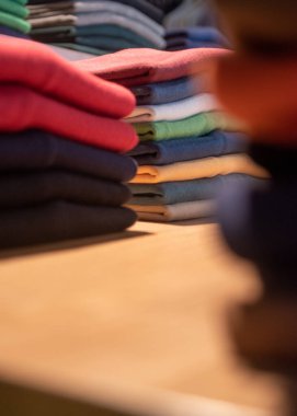 Bir butikte renkli giysiler yığını. Giysi dükkanı ticareti.