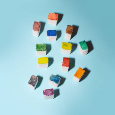 Renkli şeker küpleri mavi arka planda bir kalabalık oluşturur. İnsanlar metafor yapar. Yaratıcı gıda konsepti.