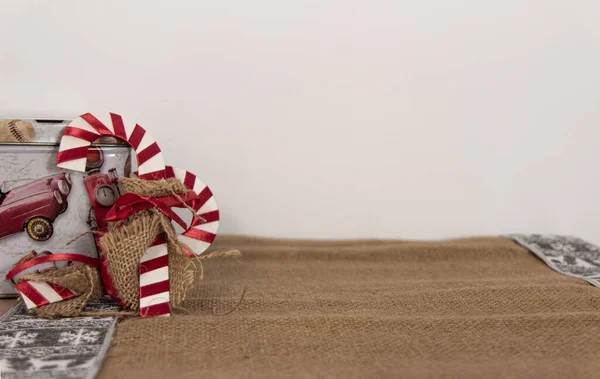 A couple of christmas canes over a jute cloth with white space
