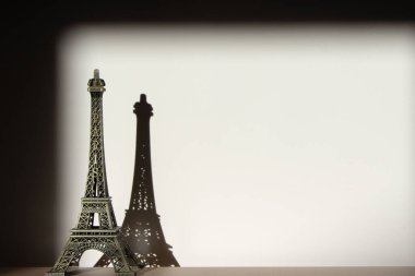 Eiffel kulesi, sert gölgeli ahşap bir masanın üzerindeki metal figür. Klasik görünüm. Boşluğu kopyala.