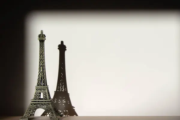 Eiffel kulesi, sert gölgeli ahşap bir masanın üzerindeki metal figür. Klasik görünüm. Boşluğu kopyala.