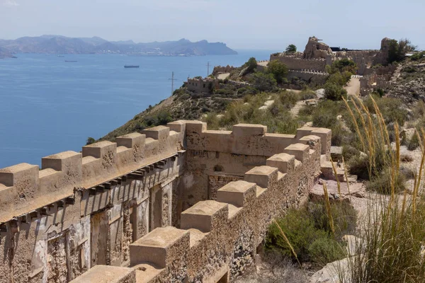 Cabo Tinoso yakınlarındaki duvarları ve kanyonları görkemli dağları ve arka planda sakin denizi görüyoruz..