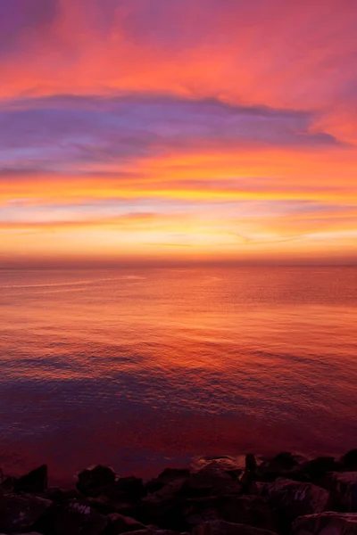 stock image Experience the awe-inspiring beauty of a vertical sunrise with vibrant tones of oranges, reds, blues, and purples. Perfect for travel, nature, and inspirational concepts.