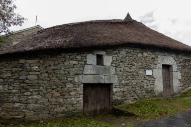 Kırsal alanda sazdan çatılı çatıları olan taştan bir kır evi. Palloza, O Cebreiro, İspanya