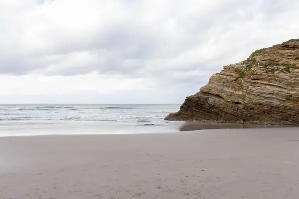 Kıyı erozyonu manzaralı kayalık kayalıklar bulutlu sakin sahil suları. Katedral plajı, Lugo, İspanya