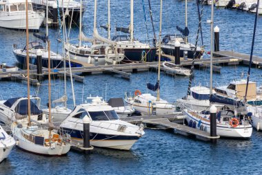 Güneşli bir günde bir marinaya yanaşmış bir tekne koleksiyonu..