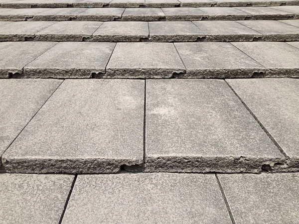 concrete roof tiles are laid on the roof in criss cross pattern