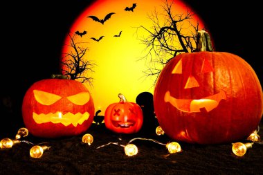 Cadılar Bayramı turuncu balkabağı arka planında sarı fenerler ve ay.