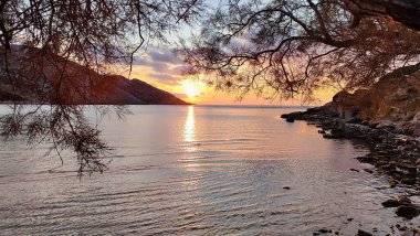 Syros 'ta bir plajda gün batımı