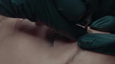 Slow-motion Video of microblading work. Permanent makeup on the eyebrows for a young woman.