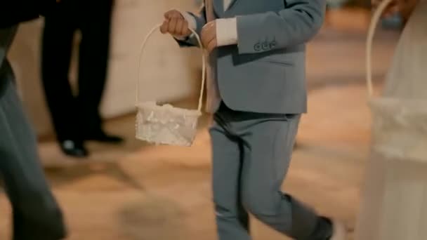一个男孩和一个手里拿着白篮子的女孩去参加婚礼 — 图库视频影像