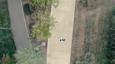 Bride and groom walking on the path in the beautiful park. Top view drone shooting at wedding day. slow motion drone shooting. top view shooting