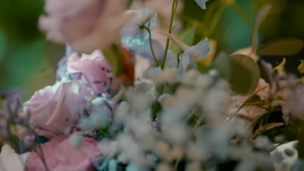 Stole Znajduje Się Bukiet Różowych Niebiesko Białych Kwiatów Oraz Kieliszki — Wideo stockowe