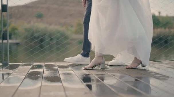 Långsam Rörelse Video Bruden Och Brudgummar Fötter Promenader Våt Träbro — Stockvideo