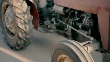 Bir traktör sürücüsü bir traktör sürer ve İsrail yerleşiminin yolunda yumurtayla tepsiler taşır. Gün boyunca traktörün yandan ve arkasından ağır çekim çekimleri.