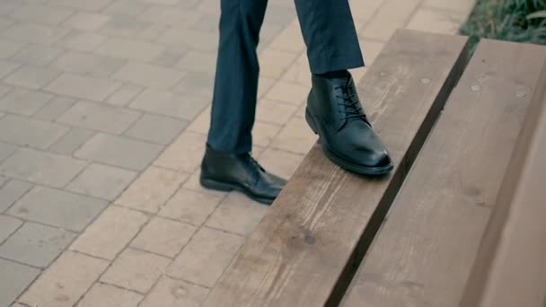 Muž Oblečený Elegantním Oblečení Položí Nohu Dřevěnou Lavičku Aby Uvázal — Stock video