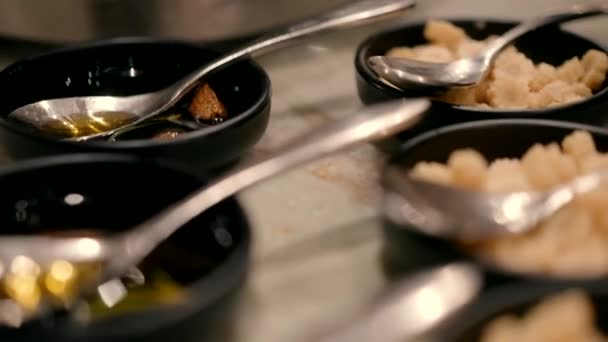 小さなカットコーンとスプーンを配置した黒いソーサー 上にソースとソーサーがきれいに提供される準備ができてレストランのテーブルの上に配置されています — ストック動画